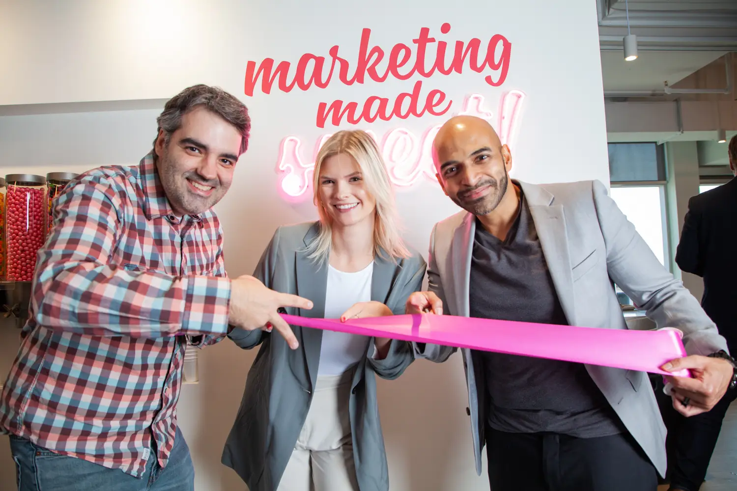 Our Candyboxers Anderson, Laura and Mahfuz doing a ribbon cutting gesture with their hands